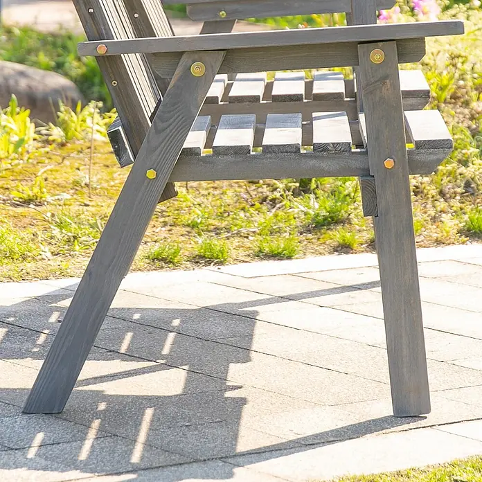 Outsunny Gartenbank - Tannenholz, Grau - Nahaufnahme einer grauen Holzgartenbank, zeigt die Lattenrostsitzfläche und Beine auf einer gepflasterten Terrasse im Freien.