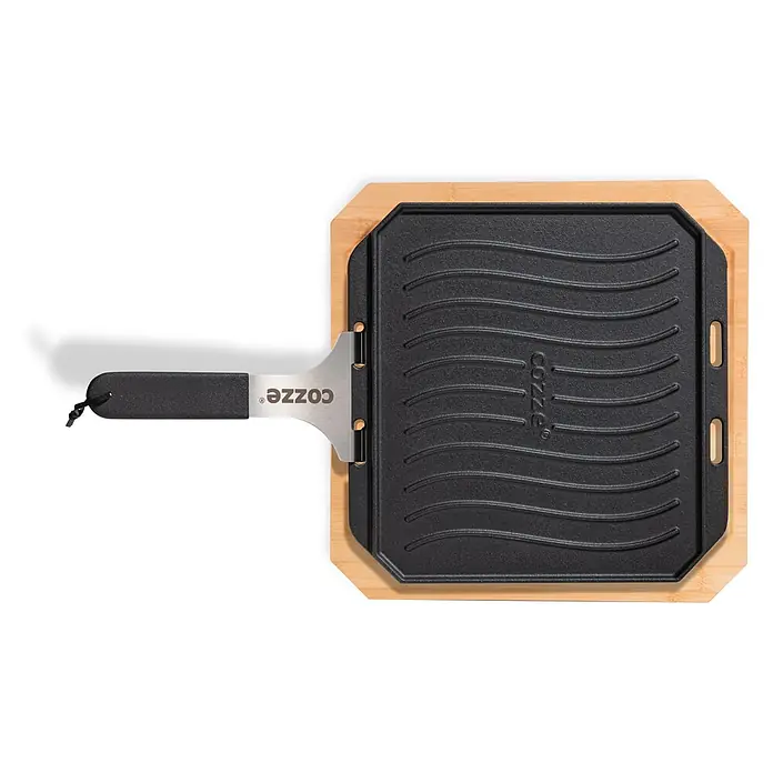 Cozze Grillpfanne - L x B: 30 x 30 cm, Höhe: 1 cm, Gusseisen - Schwarze gusseiserne Grillplatte mit Wellenmuster auf Holzbrett. Abnehmbarer Griff mit COZZE-Logo.