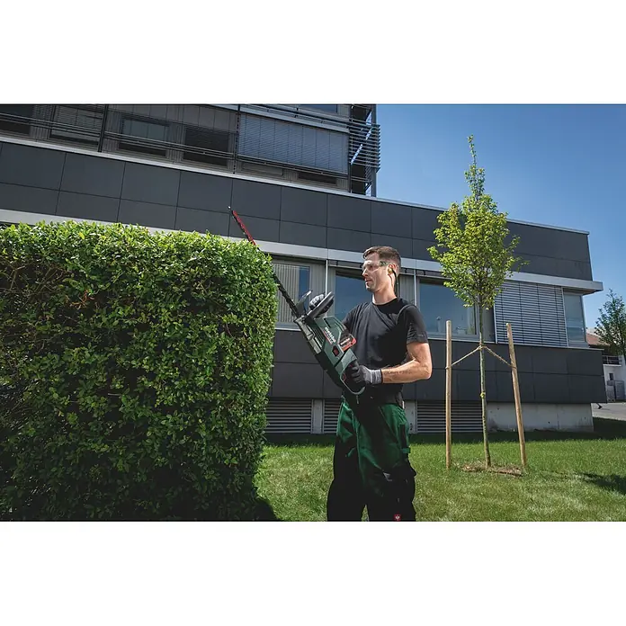 Metabo CAS 18V Akku-Heckenschere HS 18 LTX BL 65 - 18 V, Ohne Akku, Schnittlänge: 60 cm - Mann schneidet eine Hecke mit einer grün-schwarzen Metabo Heckenschere.