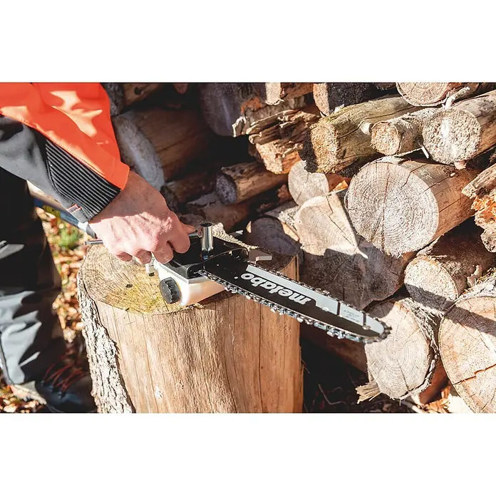 Metabo Hochentaster-Aufsatz - Passend für: Metabo Akku-Multifunktionsantrieb MA 36-18 LTX BL Q - Person in orangefarbener Jacke wartet eine Metabo Kettensäge auf einem Baumstumpf, mit gestapelten Holzscheiten im Hintergrund.