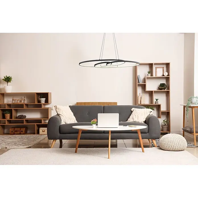 Globo LED-Pendelleuchte rund Spira - 39 W, Warmweiß - Moderne schwarze spiralförmige LED-Pendelleuchte erhellt ein zeitgenössisches Wohnzimmer mit grauem Sofa und Holzregalen.