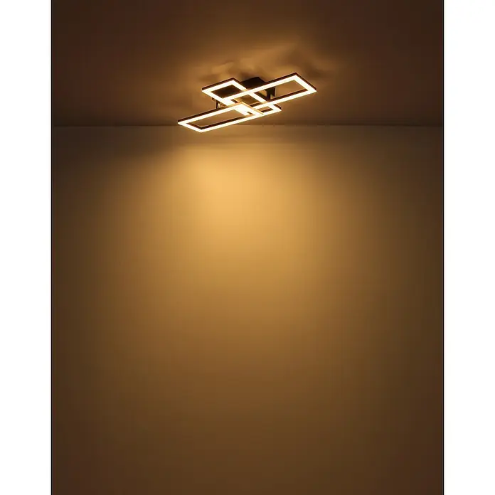 Globo Plafón LED Drew - 20 W, L x An x Al: 61,4 x 19,5 x 9 cm, Negro, Blanco cálido - Lámpara de techo moderna oscura con elementos LED rectangulares interconectados, proyectando luz cálida sobre una pared.