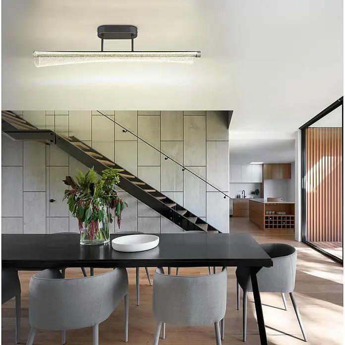 Globo LED-Deckenleuchte Malinda - 28 W, L x B x H: 810 x 120 x 190 mm - Elegante lineare Deckenleuchte mit dunkler Halterung und strukturierter klarer Röhre, die einen modernen Essbereich beleuchtet.