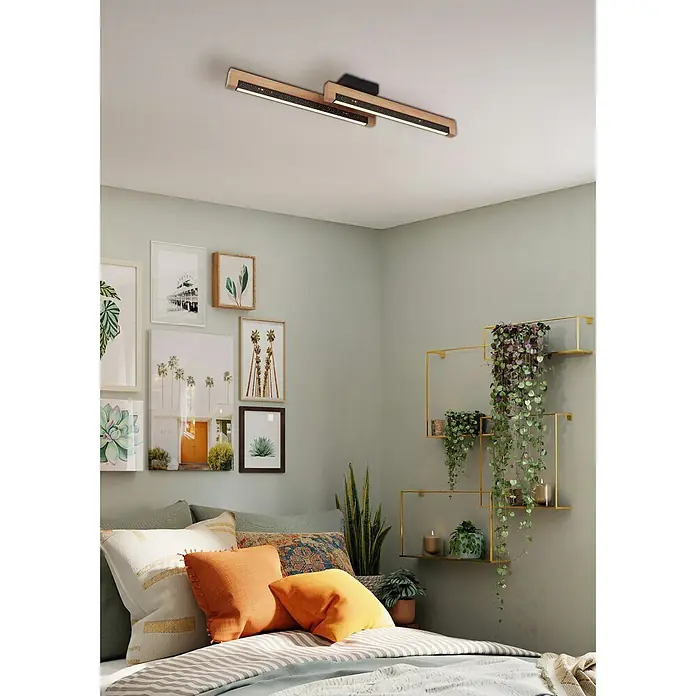 Globo LED-Deckenleuchte Starla - 12 W, L x B x H: 700 x 130 x 80 mm - Moderne Deckenleuchte aus Holz und Schwarz mit dekorativen Sternen-LED-Streifen, beleuchtet ein Schlafzimmer.