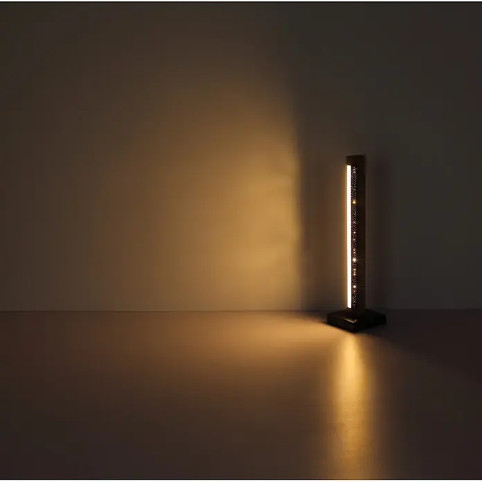Globo LED-Tischleuchte Starla - 8 W, L x B x H: 120 x 120 x 480 mm - Eine hohe, dunkle Lampe mit vertikalem LED-Streifen und dekorativ perforierter Seite, die warmes Licht ausstrahlt.