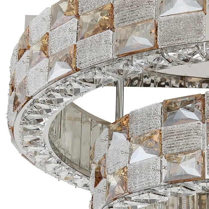 Globo LED-Deckenleuchte Lidia - 55 W - Nahaufnahme einer luxuriösen Kristallleuchte mit klaren, strukturierten und bernsteinfarbenen, facettierten Kristallen auf einem silbernen Rahmen.