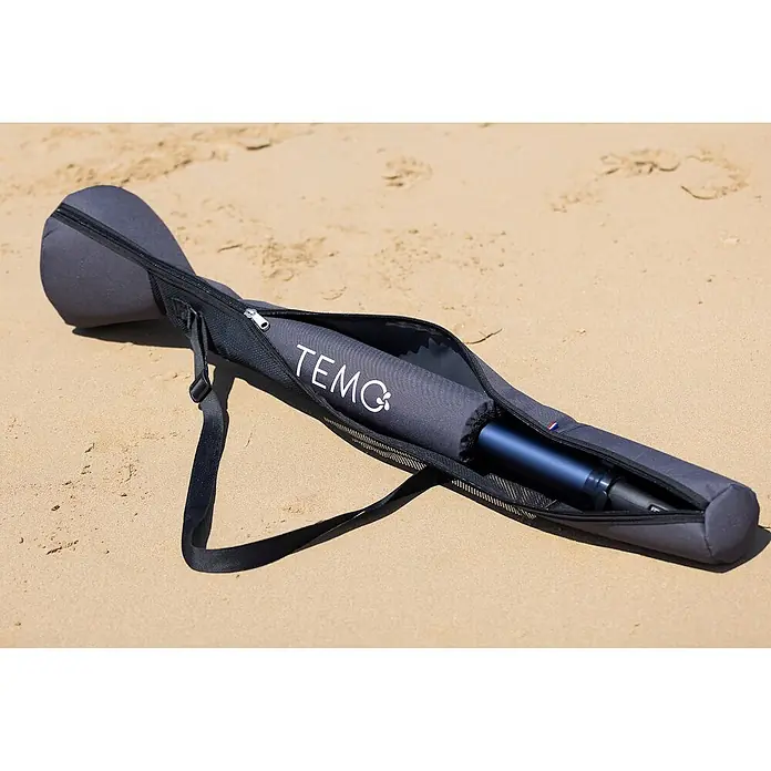 Temo Transporttasche - Passend für: Außenbordmotor TEMO 450 - Dunkelgraue TEMO-Tragetasche, teilweise geöffnet, zeigt einen dunkelblauen Elektromotor, auf Sand liegend.