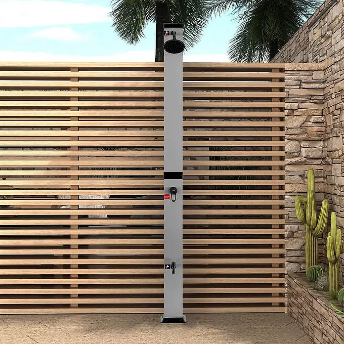 Home Deluxe Solardusche OLYMP - Höhe: 217 cm, Kunststoff, Gebürstetes Nickel / Schwarz, 40 l - Graue Außendusche mit schwarzem Duschkopf, Handbrause und Wasserhahn, vor einem Holzlamellenzaun.