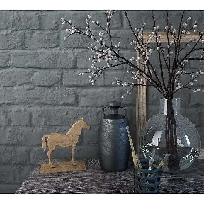 Marburg Loft Superior Vliestapete Steinoptik - Schwarz, Steinoptik, 10,05 x 0,53 m - Ein rustikales Deko-Arrangement mit einem Holzpferd, einer dunklen Keramikvase und Weidenkätzchenzweigen in einer Glasvase, neben Pinseln in einem Halter auf einem Holztisch.