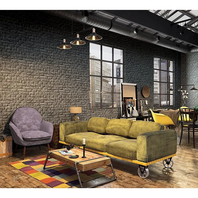 Marburg Loft Superior Vliestapete Steinoptik - Schwarz, Steinoptik, 10,05 x 0,53 m - Ein Wohnzimmer im Industriestil mit dunklen Ziegelwänden, freiliegenden Rohren, einem gelben Sofa auf Rollen und einem lila Sessel auf buntem Teppich.