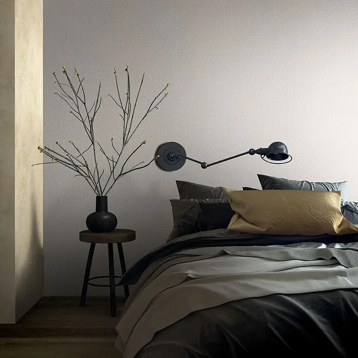 Vliestapete - Braun, Sonstiges, 10,05 x 0,53 m - Modernes Schlafzimmer mit strukturierter hellgrauer Wand, dunkler Bettwäsche, goldenem Kissen und Wandlampe.