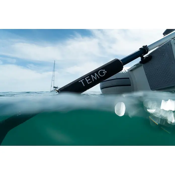 Temo Schwimmhilfe - Passend für: Elektro-Außenbordmotor Temo 450 - Schwarzer TEMO Elektromotor, teilweise im Wasser am Heck eines Bootes.