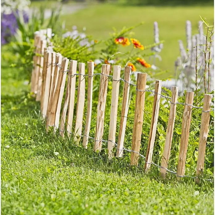 Windhager Beeteinfassung Staketenzaun - L x H: 120 x 50 cm, Natur - Ein kurzer, rustikaler Holzzaun aus vertikalen Pfählen, mit Draht verbunden, trennt Rasen von Blumenbeet.