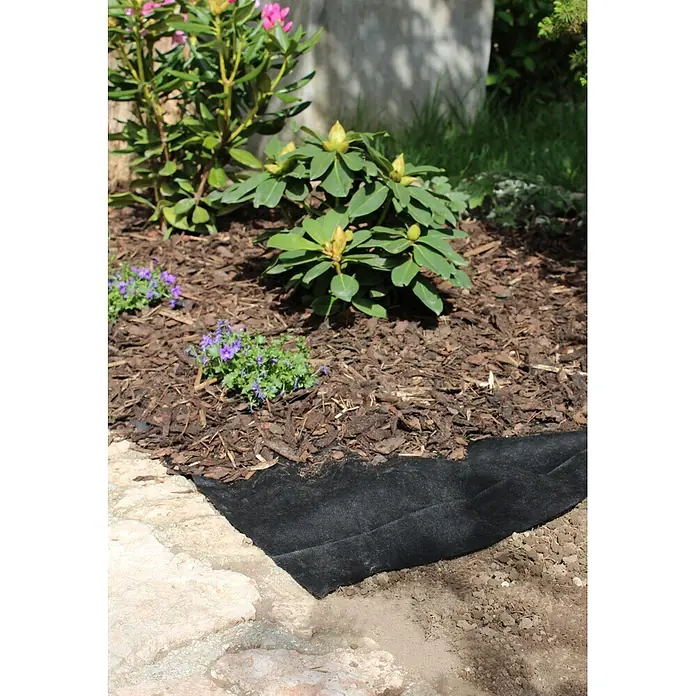 Windhager Unkrautvlies - Vlies, 10 x 0,9 m - Schwarzes Unkrautvlies, teilweise in einem Gartenbeet verlegt, sichtbar neben einem Steinweg und unter Rindenmulch.