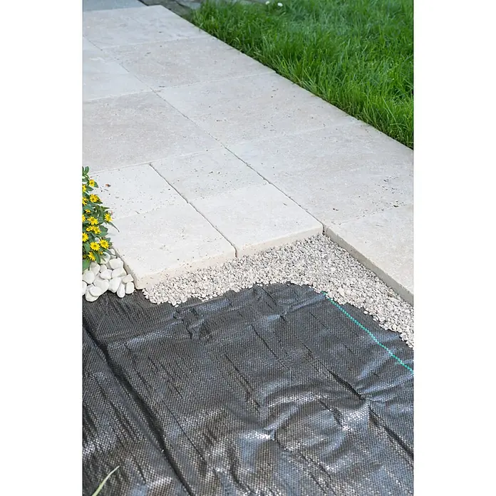 Windhager Unkrautabwehrgewebe Unterboden-Gewebe - Vlies, 25 x 2 m - Helle Pflasterplatten werden auf einer Kiesschicht und schwarzem Unkrautvlies neben grünem Gras verlegt.