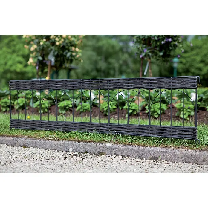 Windhager Beeteinfassung Typ 14 PVC Rattan - L x H: 100 x 35 cm, Anthrazit - Dunkelgrauer, geflochtener Gartenzaun mit Metallrahmen, grenzt ein Blumenbeet im Garten ab.
