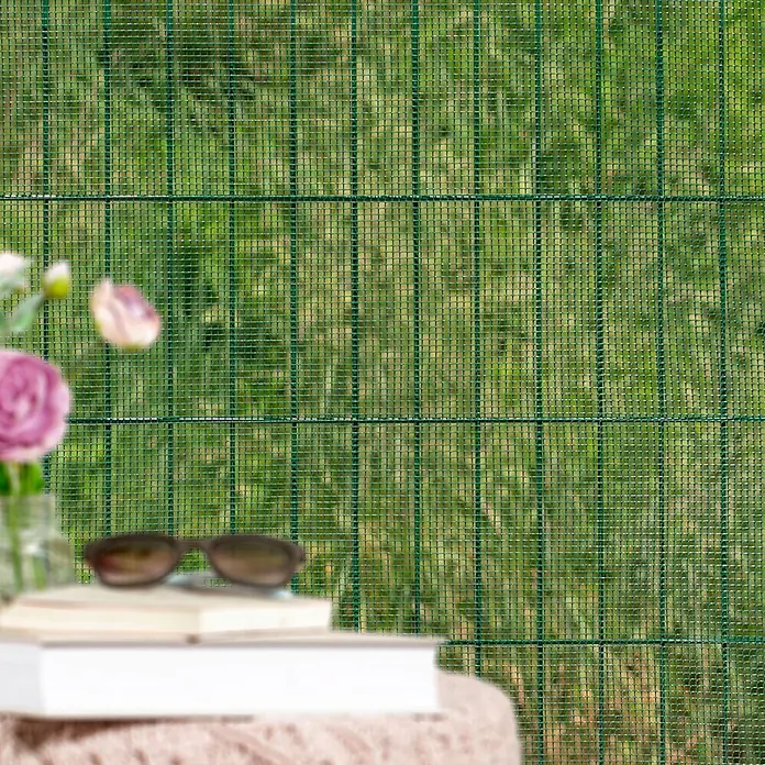 Windhager Drahtgitter - Grün, B x H: 3 x 1 m, Maschenweite: 10 x 10 mm - Grüner Maschendrahtzaun für Privatsphäre, mit unscharfen Blumen und Büchern im Vordergrund.
