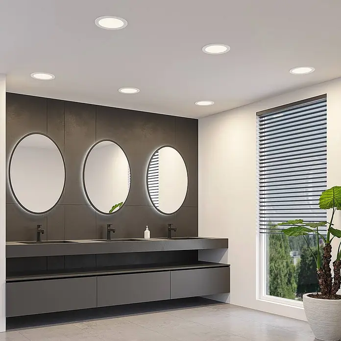 Prios Deckenstrahler Cadance - L x B x H: 22 x 22 x 3,2 cm, weiß / opal, weiß / opal - Runde LED-Einbauleuchten beleuchten ein modernes Badezimmer mit dunkelgrauem Dekor.