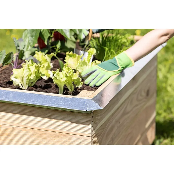 Windhager Schneckenblech Eckteil - Metall, Silber - Hochbeet aus Holz mit Metalleinfassung, gefüllt mit Pflanzen, die von einer Person mit Gartenhandschuhen gepflegt werden.