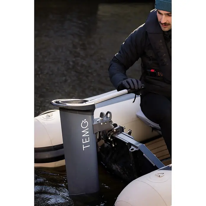 Temo Elektro-Außenbordmotor 1000 - 1.100 W, Pinnensteuerung - Eine Person bedient einen grauen TEMO Elektro-Außenbordmotor an einem Schlauchboot im Wasser.