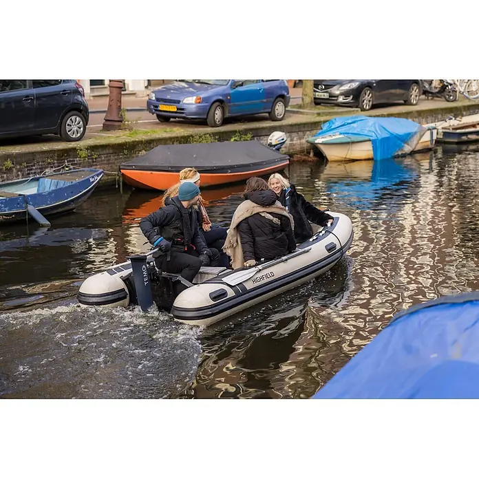 Temo Elektro-Außenbordmotor 1000 - 1.100 W, Pinnensteuerung - Ein cremefarbenes und schwarzes Highfield Schlauchboot mit Temo Elektromotor befördert Personen auf einem Kanal.