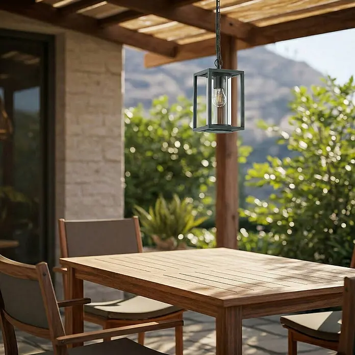 Lucande Außenwand- & Deckenleuchte Ferda - grün, grün, IP44 - Schwarze rechteckige Außenpendelleuchte mit Klarglaszylinder und Edison-Birne, von einer Pergola über einem Holztisch hängend.