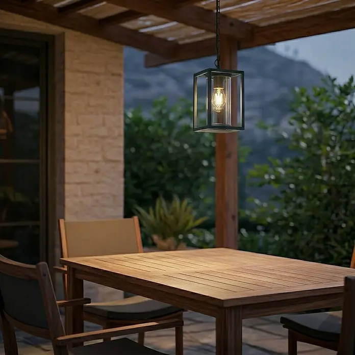Lucande Außenwand- & Deckenleuchte Ferda - grün, grün, IP44 - Schwarze Outdoor-Laterne mit Klarglas und warmer Glühbirne, hängt über einem Holzesstisch auf einer Terrasse in der Dämmerung.
