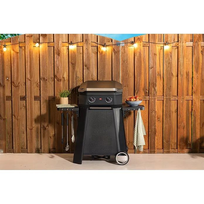 Cozze Rollwagen - B x T x H: 127 x 64,5 x 74,5 cm, Stahl, Schwarz, Passend für: Cozze 500er Grillserie - Schwarzer Outdoor-Gasgrill mit Edelstahlplatte, zwei Seitenablagen und Rollen, einsatzbereit auf einer Terrasse.