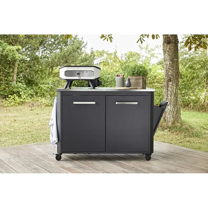 Cozze Outdoorküchen-Modul - Schwarz, B x T x H: 120 x 60 x 90 cm - Dunkelgraue Outdoor-Kücheninsel mit weißem und schwarzem Pizzaofen darauf, auf einer Holzterrasse.
