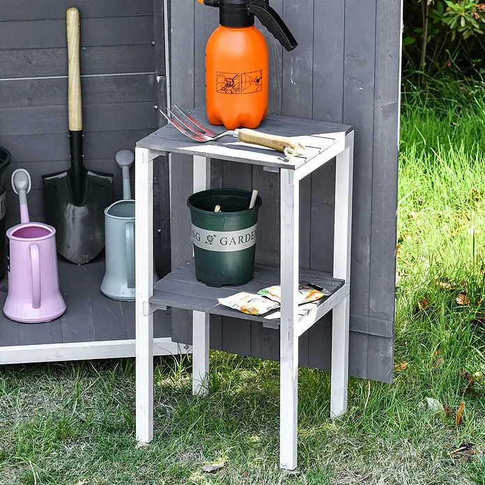 Outsunny Geräteschrank - Außenbreite inkl. Dachüberstand: 139 cm, Außentiefe inkl. Dachüberstand: 75 cm, Holz, Grau+Weiß - Grau-weißes zweistufiges Gartenregal mit verschiedenen Werkzeugen und Pflanztöpfen im Freien.