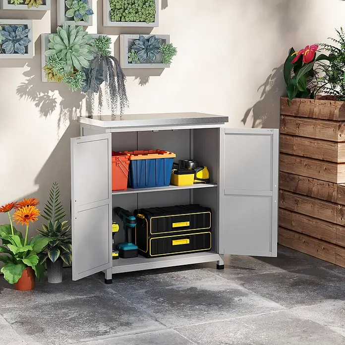 Outsunny Geräteschrank - Außenbreite inkl. Dachüberstand: 79 cm, Außentiefe inkl. Dachüberstand: 43 cm, Holz, Grau - Grauer Outdoor-Aufbewahrungsschrank mit silberner Platte, geöffnet, um bunte Behälter und Werkzeuge auf Regalen auf einer Terrasse zu zeigen.