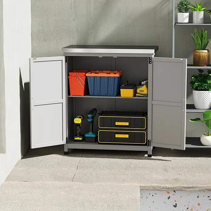 Outsunny Geräteschrank - Außenbreite inkl. Dachüberstand: 79 cm, Außentiefe inkl. Dachüberstand: 43 cm, Holz, Grau - Grauer Lagerschrank mit offenen Türen, gefüllt mit Werkzeugen und Behältern, auf einer Betonterrasse neben einem Pflanzenregal.
