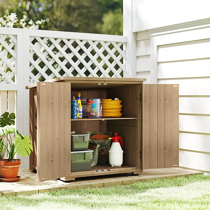 Outsunny Geräteschrank - Außenbreite inkl. Dachüberstand: 88 cm, Außentiefe inkl. Dachüberstand: 77,5 cm, Holz, Naturholz - Hölzerner Gartenschrank mit zwei offenen Türen, der Regale voller Gartenwerkzeuge und -zubehör auf einer Terrasse neben einem Zaun zeigt.