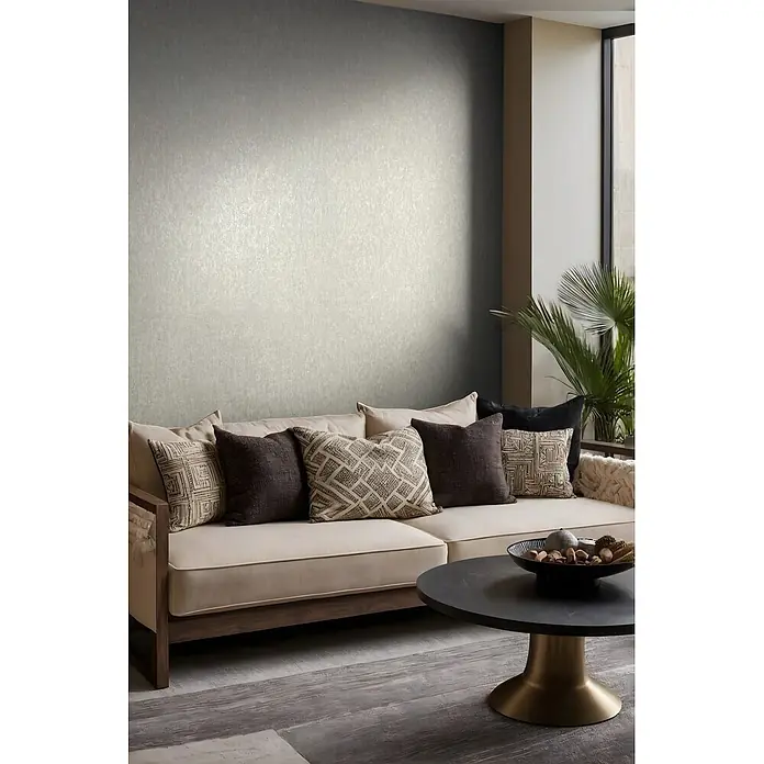 Marburg Ritus Vliestapete Uni I - Beige, Uni, 10,05 x 0,53 m - Helle graue strukturierte Tapete in einem modernen Wohnzimmer, hinter einem beigen Sofa mit Zierkissen.