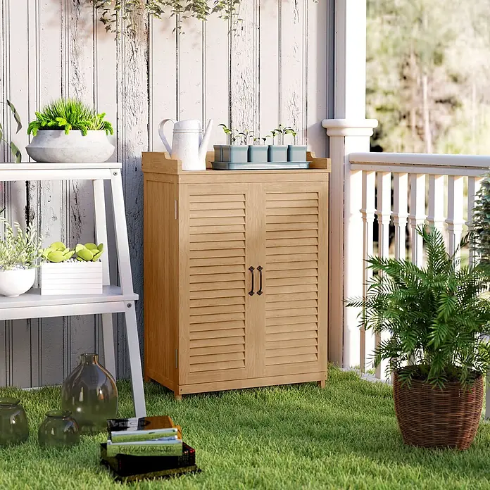 Outsunny Geräteschrank - Außenbreite inkl. Dachüberstand: 66,5 cm, Außentiefe inkl. Dachüberstand: 40 cm, Holz, Gelb - Hellesbrauner hölzerner Gartenschrank mit Jalousietüren, mit Gartenbedarf auf einer Terrasse.