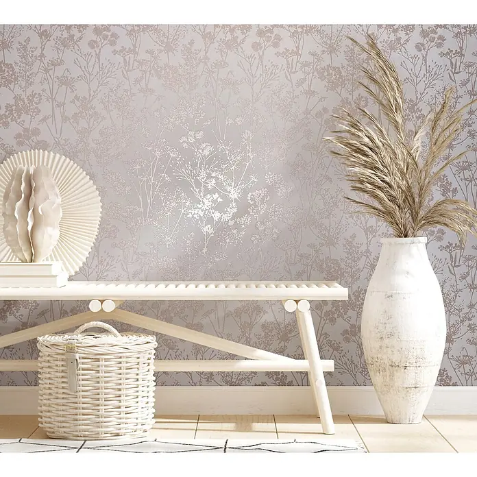Marburg Vliestapete Novamur Mona Floral I - Weiß-Beige, Floral, 10,05 x 0,53 m - Zarte botanische Tapete mit metallischen, rosafarbenen Mustern bedeckt eine Wand in einem ruhigen Raum, hinter einer Holzbank und Vase.