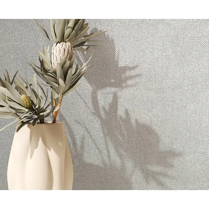 Marburg Whisper Vliestapete Putzoptik II - Grau, Sonstiges, 10,05 x 0,53 m - Dekoratives Arrangement mit blassen Proteablüten und grünen Blättern in einer cremefarbenen Vase, Schatten auf strukturierter Wand.
