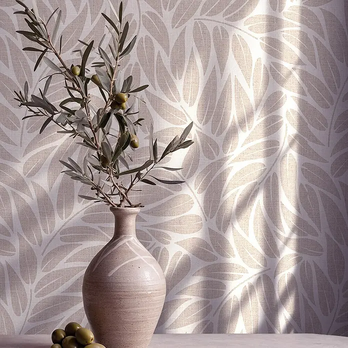 Marburg Boho Vliestapete Floral I - Beige, Floral, 10,05 x 0,53 m - Olivenzweig mit grünen Oliven in einer strukturierten Keramikvase, auf einem Tisch vor einer gemusterten Wand mit natürlichen Schatten.