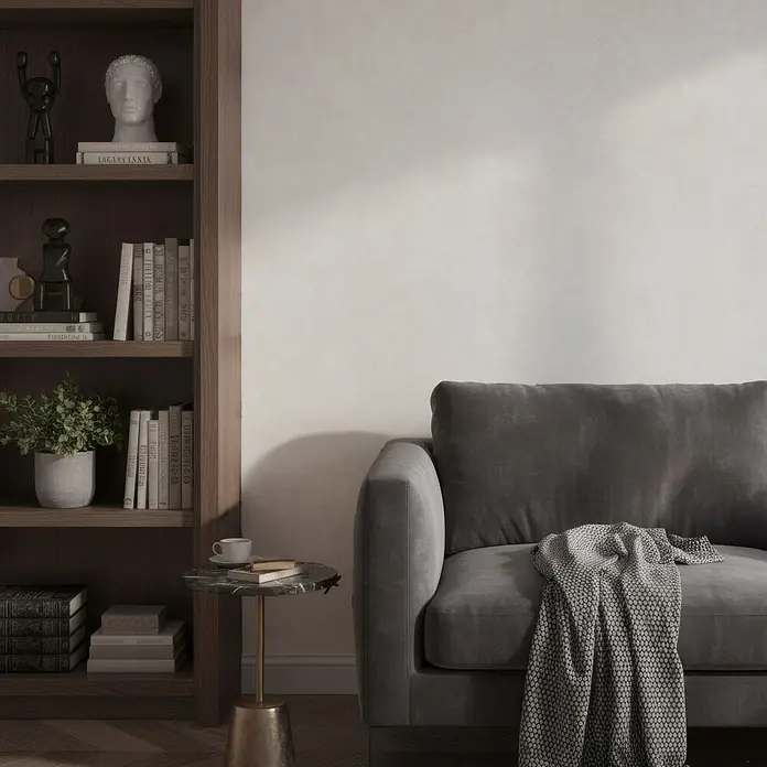 Marburg Whisper Vliestapete Putzoptik - Beige, Sonstiges, 10,05 x 0,53 m - Dunkelgraues Sofa mit gemusterter Decke, in einem modernen Wohnzimmer mit Holzregal.