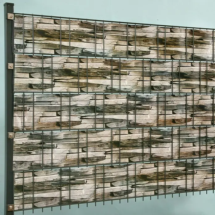 Stabilit Sichtschutzstreifen - Schiefer, 2.050 x 19 cm - Nahaufnahme einer Gabionenwand mit Steinfüllung und Metallgitter, ideal für Garten- und Landschaftsbau, robust und dekorativ.