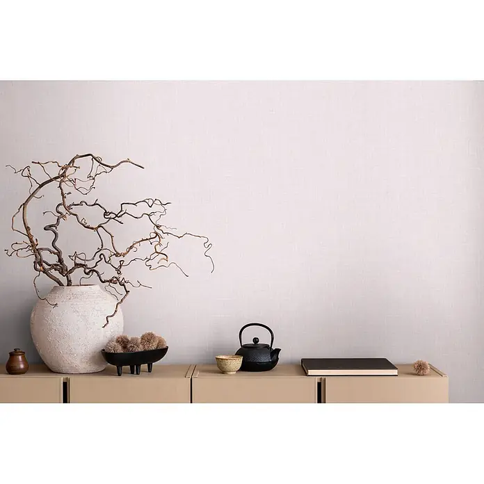 Marburg Boho Vliestapete Uni I - Rosa, Uni, 10,05 x 0,53 m - Neutrale Wohndeko: große strukturierte Vase mit Ästen, schwarze Schale, Teekanne, Holzdose und Buch auf hellem Schrank.