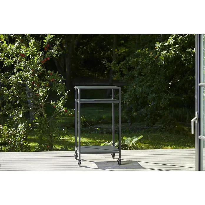 Cozze Grilltisch - B x T x H: 60 x 60 x 110 cm, Stahl - Dunkelgrauer, mehrstufiger Metall-Outdoor-Wagen mit Rollen auf Holzterrasse im Garten.