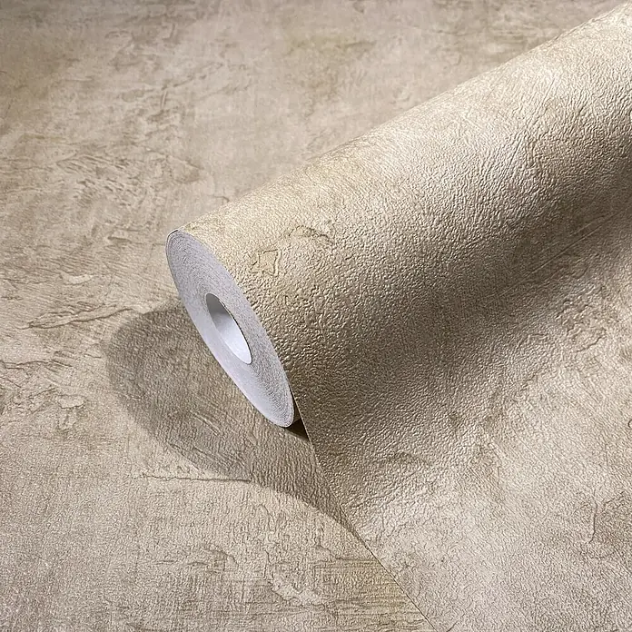 Marburg Loft Superior Vliestapete Struktur I - Camel, Sonstiges, 10,05 x 0,53 m - Beigefarbene, texturierte Tapetenrolle teilweise abgerollt, zeigt ein steinähnliches Muster.