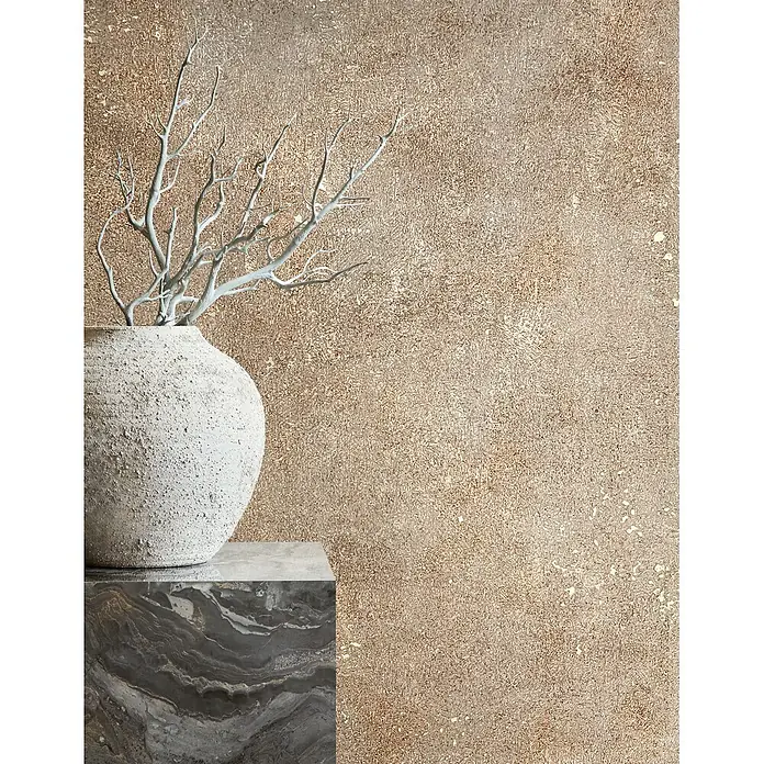 Marburg City Glow Vliestapete Uni - Beige-Braun, Uni, 10,05 x 0,53 m - Strukturierte hellgraue Vase mit weißen Deko-Ästen auf einem dunklen Marmorsockel, vor einer warmen, strukturierten Wand.