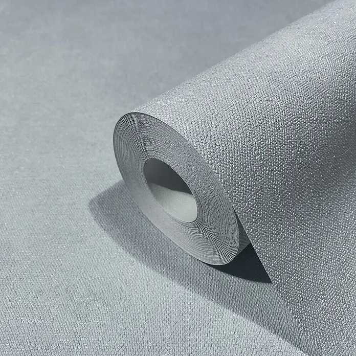 Marburg Shades Iconic Vliestapete Uni - Blau-Grau, Uni, 10,05 x 0,53 m - Hellgraue strukturierte Tapetenrolle mit subtilen metallischen Sprenkeln, teilweise abgerollt.