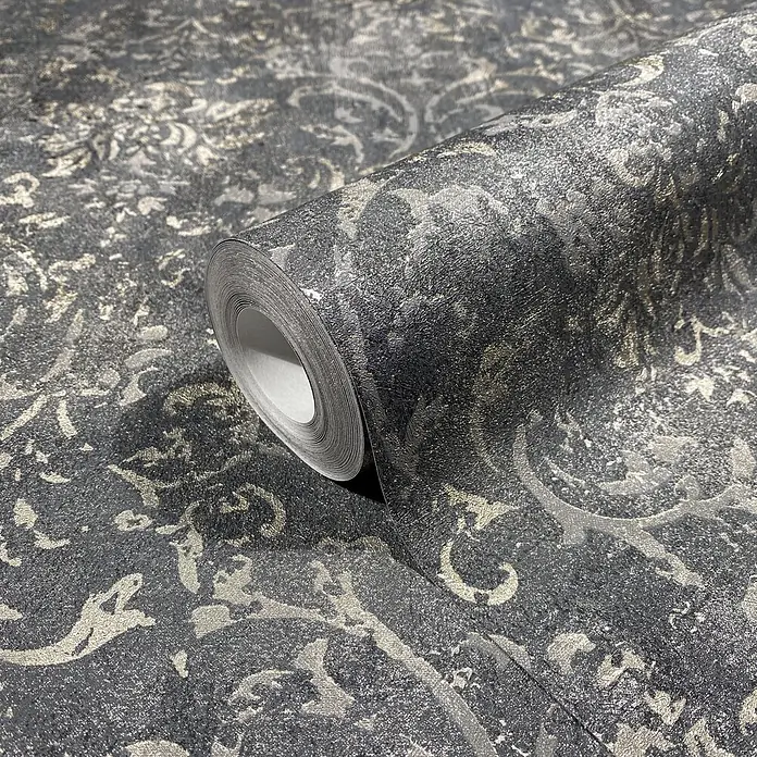 Marburg City Glow Vliestapete Ornamental - Schwarz-Silber, Ornament, 10,05 x 0,53 m - Dunkelgraue, texturierte Tapetenrolle mit metallischem Damastmuster, teilweise abgerollt.