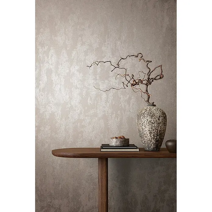 Marburg City Glow Vliestapete Struktur - Grau-Pearl, Sonstiges, 10,05 x 0,53 m - Strukturierte Wandverkleidung in Hell-Taupe mit subtilem, schimmerndem Pinselstrichmuster, hinter Holzkonsolentisch mit Deko.