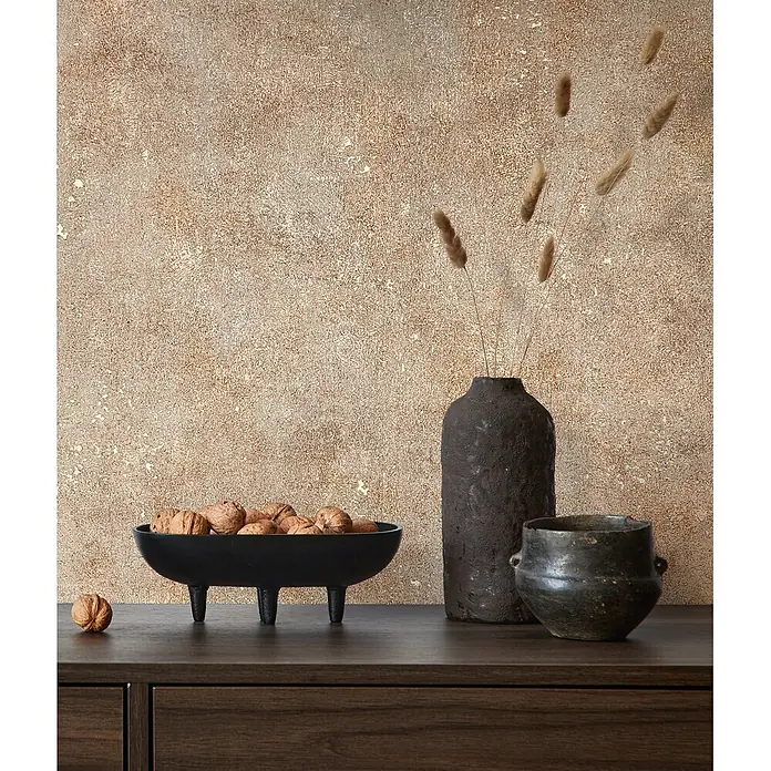 Marburg City Glow Vliestapete Uni - Beige-Braun, Uni, 10,05 x 0,53 m - Schwarze, strukturierte Schale mit drei Beinen, gefüllt mit Walnüssen, auf einem dunklen Holzschrank, Teil einer rustikalen Einrichtung.