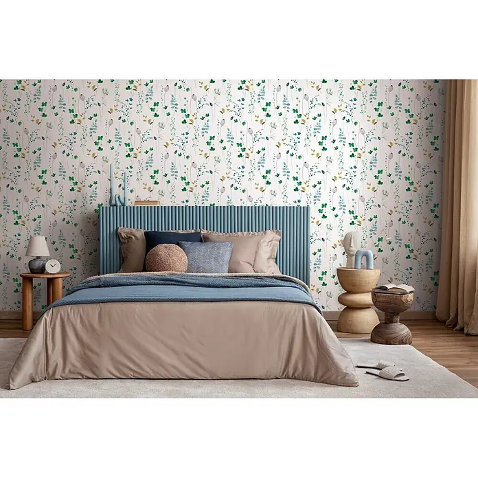 Marburg Novamur Plus Fresh UP Vliestapete Floral V - Weiß-Grün, Floral, 10,05 x 0,53 m - Ein beigefarbenes Bettwäscheset mit blauem Strickplaid auf einem Bett in einem Schlafzimmer mit gemusterter Tapete.