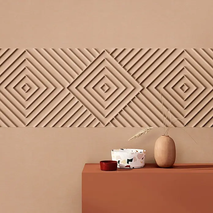 Marburg Shades Iconic Vliestapete Grafik IV - Beige, Grafisch, 10,05 x 0,53 m - Terrakotta-Vase mit Trockengras, Terrazzo-Schale und rote Tasse auf einem orangefarbenen Podest vor einer gemusterten beigen Wand.